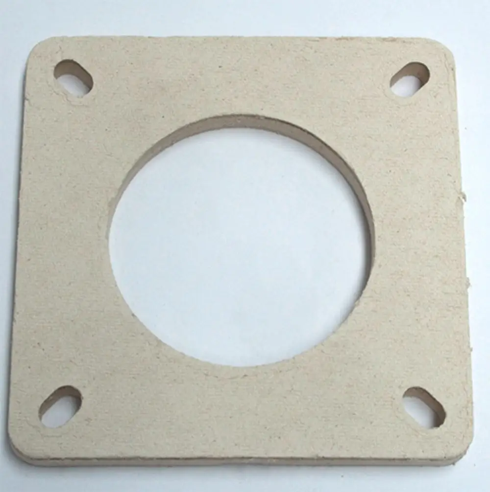 Daikin Dichtung in quadratischer Form mit kreisförmiger Aussparung, ausgestattet mit vier Bohrungen zur Befestigung. Neutralfarbener, flacher Werkstoff an weißem Hintergrund.